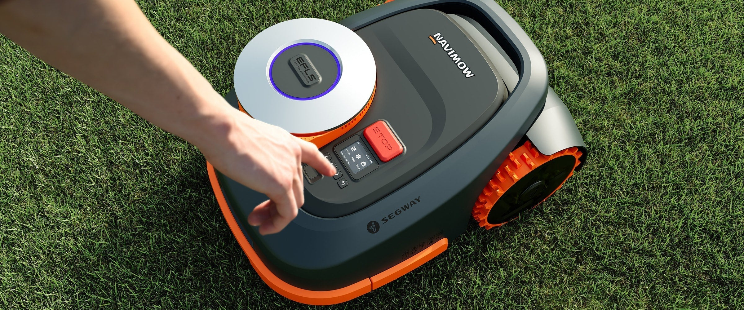 A hand is touching a Segway Navimow robot lawn mower.