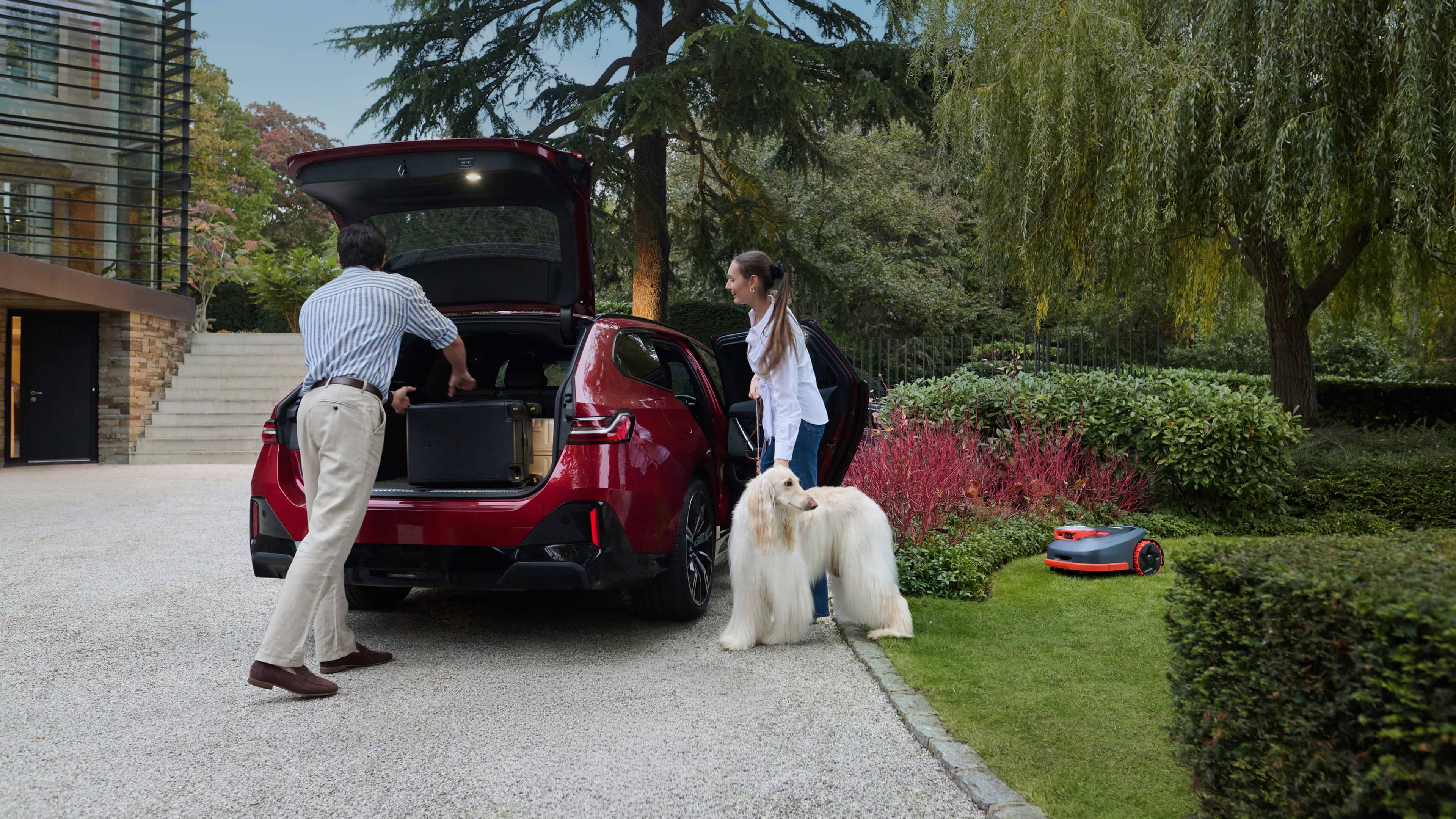 Couple loading car beside Segway Navimow i110N robot lawn mower.