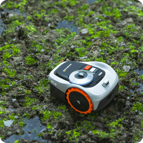 Navimow i series robot lawn mower on muddy mossy ground.