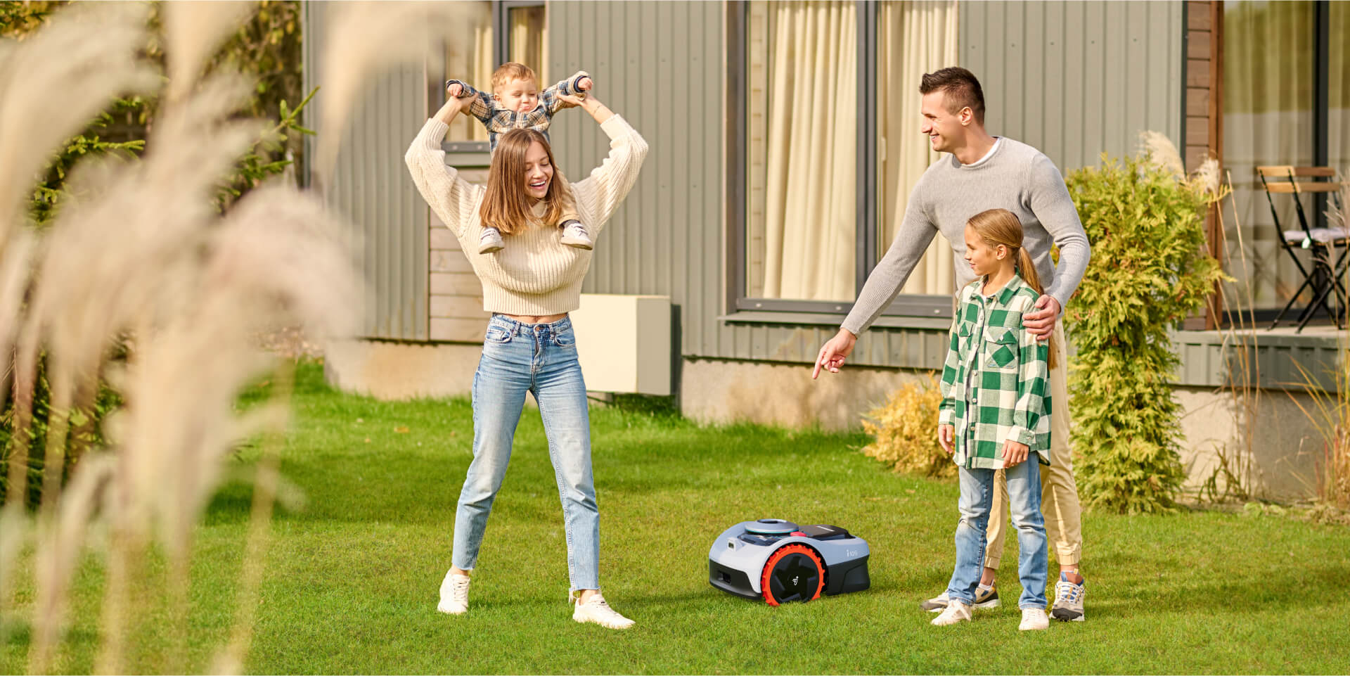 A family watches as their Navimow i105 robot lawn mower works.