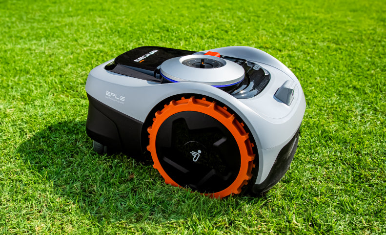 The Navimow i110 robot lawn mower sits on green grass.