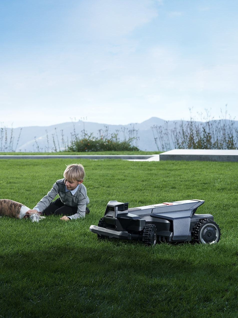 Segway Navimow i110E robot lawn mower on a grassy field.