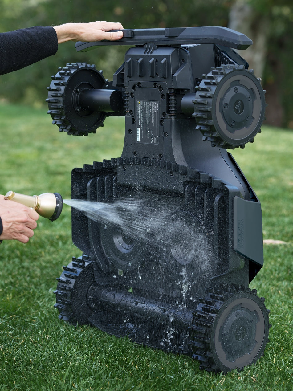 Navimow i110N robot lawn mower is being hosed with water.