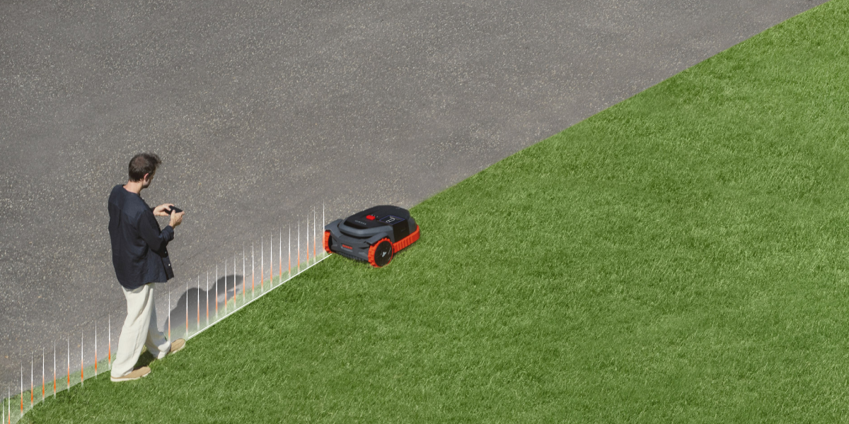 Navimow i110N robot lawn mower operates on a green field.