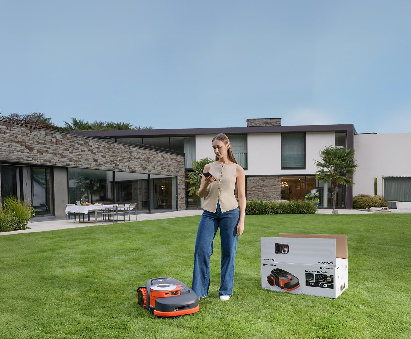 Navimow H210 robot lawn mower stands on the green lawn.