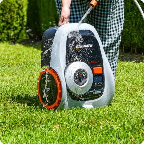 Navimow i105E robot lawn mower being washed in a garden.