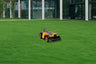 Navimow i110E robot lawn mower mows the green grass field.