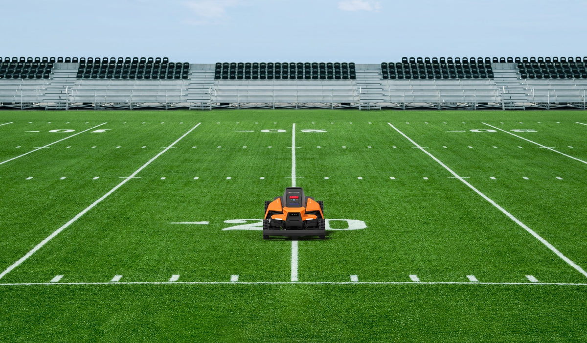 Navimow i110N robot lawn mower mows grass on football field.