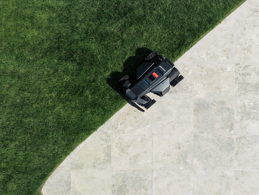 Navimow i110N robot lawn mower cutting grass in a backyard.