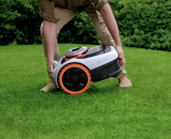 Man lifting this Segway Navimow i Series robot lawn mower.