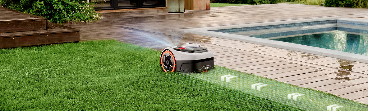 Navimow AWD robot lawn mower mows grass near a pool.