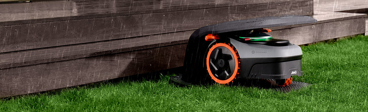 Segway Navimow AWD robot lawn mower is charging in rain.