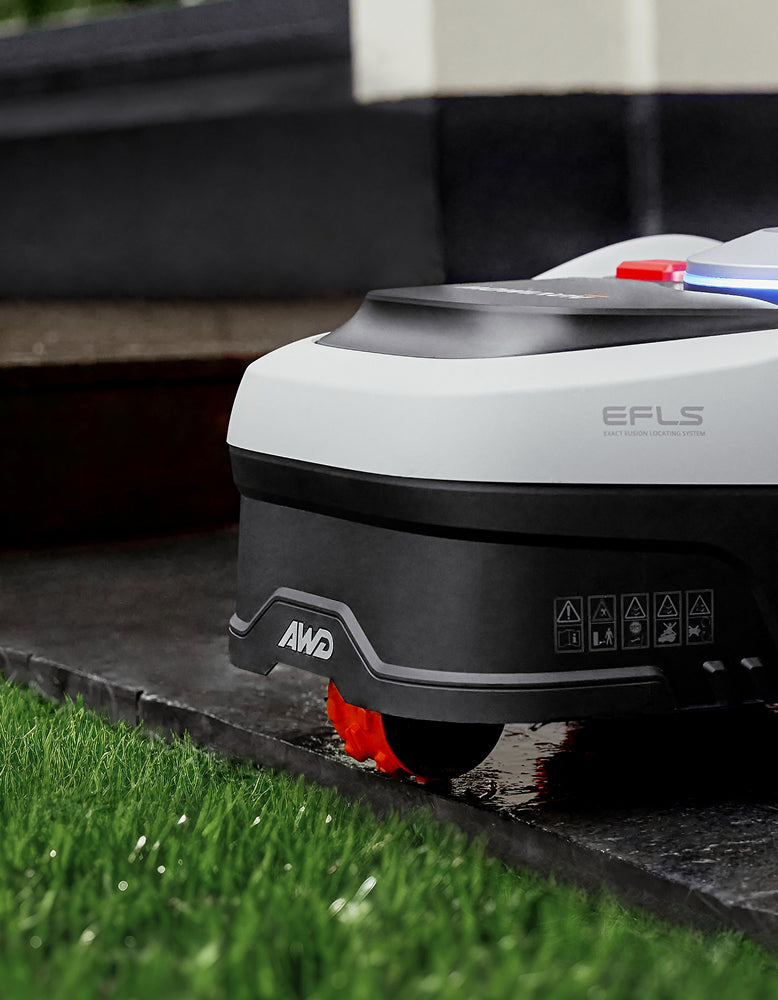 Navimow i110N robot lawn mower mows the wet green grass.