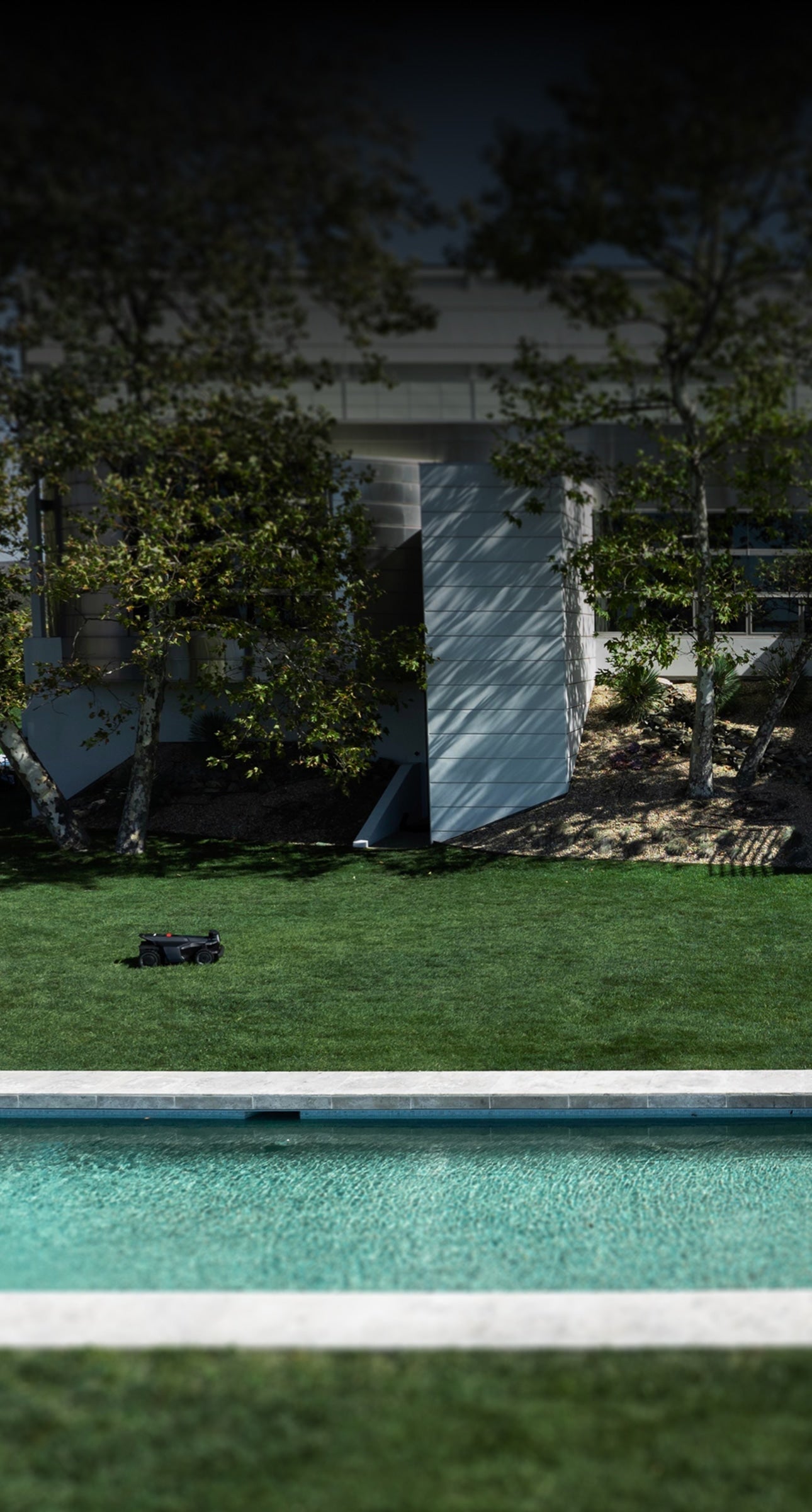 Segway Navimow i110N robot lawn mower mows lawn near pool.